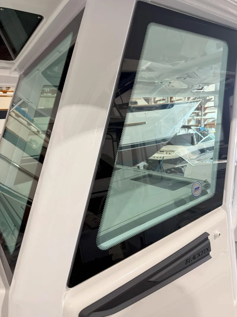 Slide: The Image of 2026 Blackfin 242HB boat window detail in a showroom setting. - 34