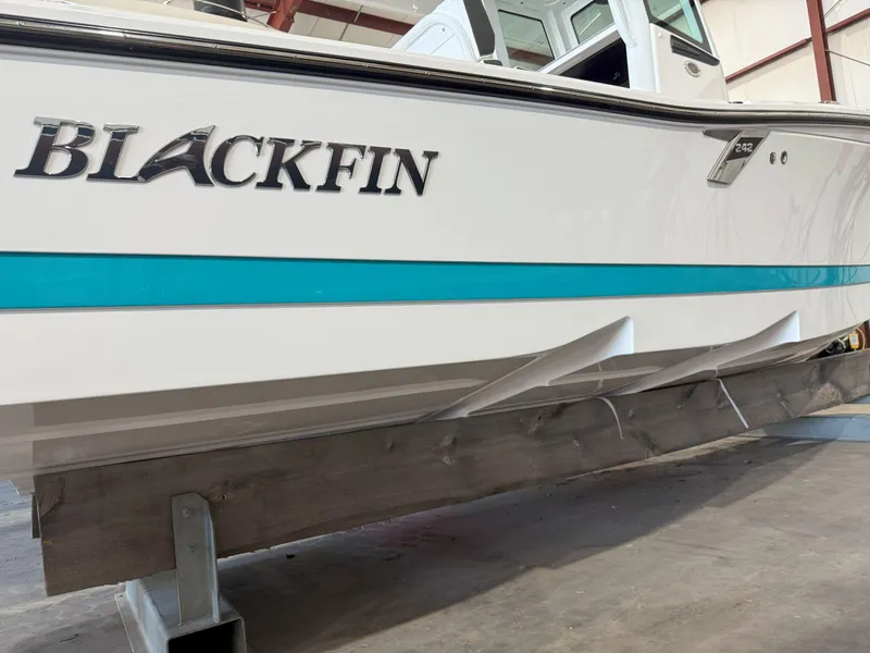 Slide: The Image of 2026 Blackfin 242HB boat in a warehouse, showcasing sleek design and branding. - 4