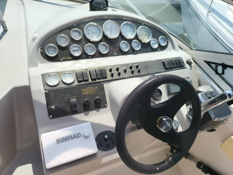 Slide: The Image of Dashboard of a 2004 Cruisers 280CXi boat with gauges and steering wheel. - 15