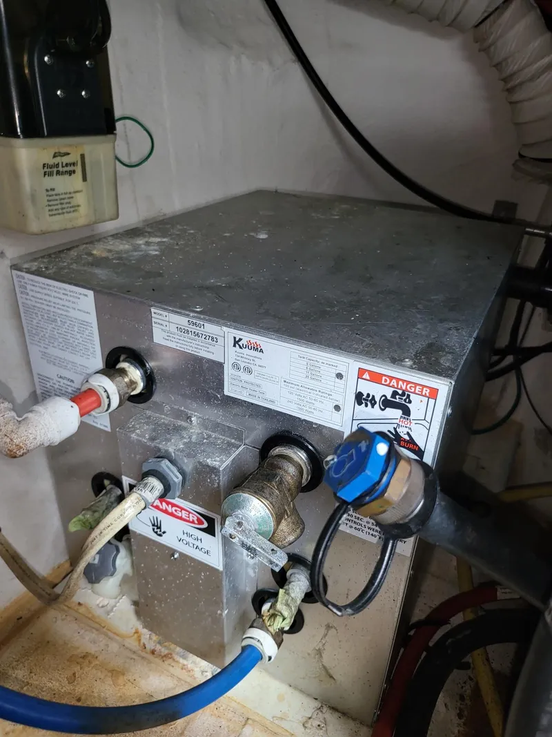 Slide: The Image of 2004 Cruisers 280CXi engine compartment with various hoses and warning labels. - 19