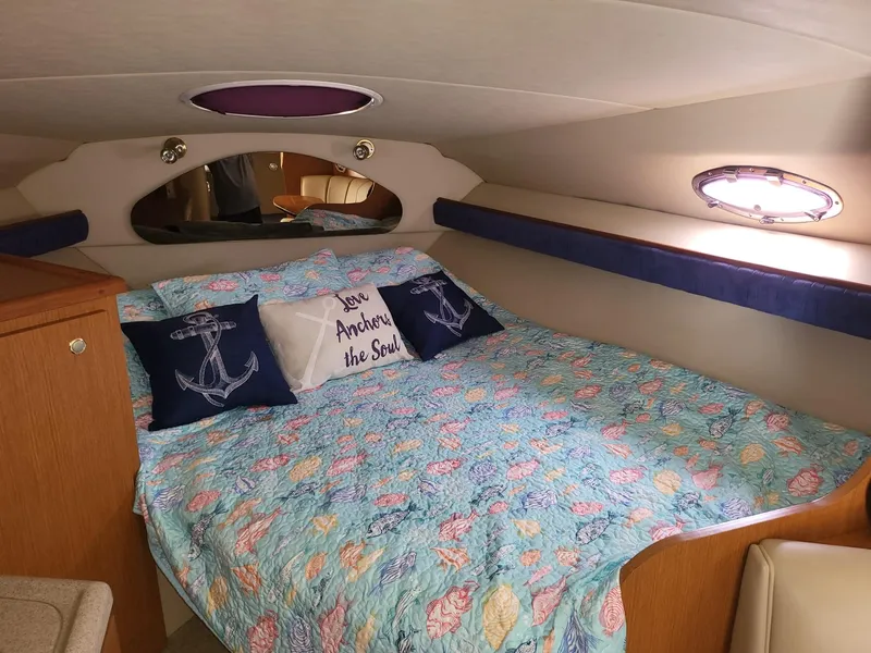 Slide: The Image of Cozy cabin interior of 2004 Cruisers 280CXi with nautical-themed bedding and pillows. - 4