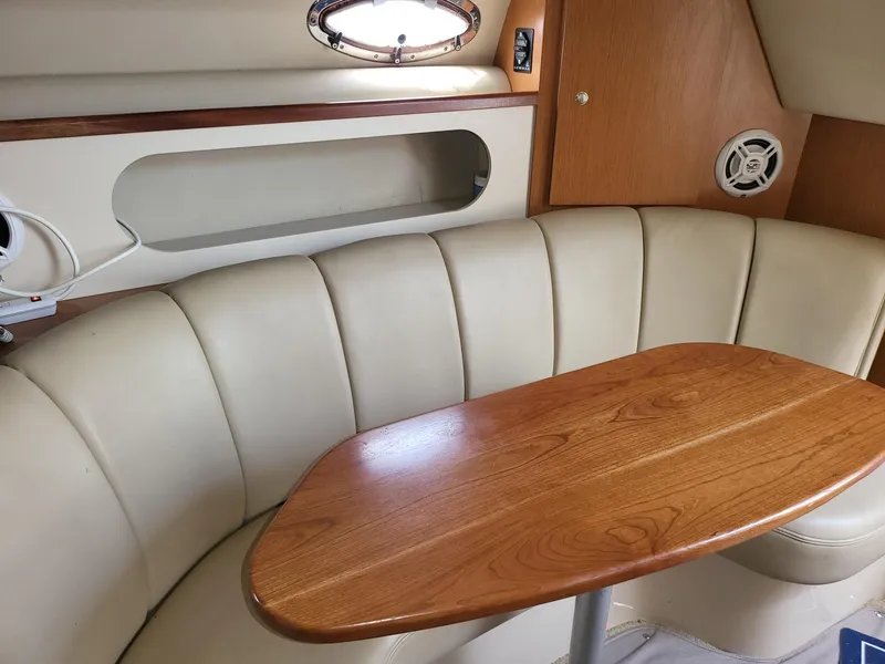 Slide: The Image of 2004 Cruisers 280CXi cabin interior with beige seating and wooden table. - 5