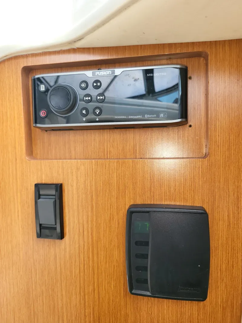 Slide: The Image of 2004 Cruisers 280CXi control panel with audio system and switches on wooden dashboard. - 11