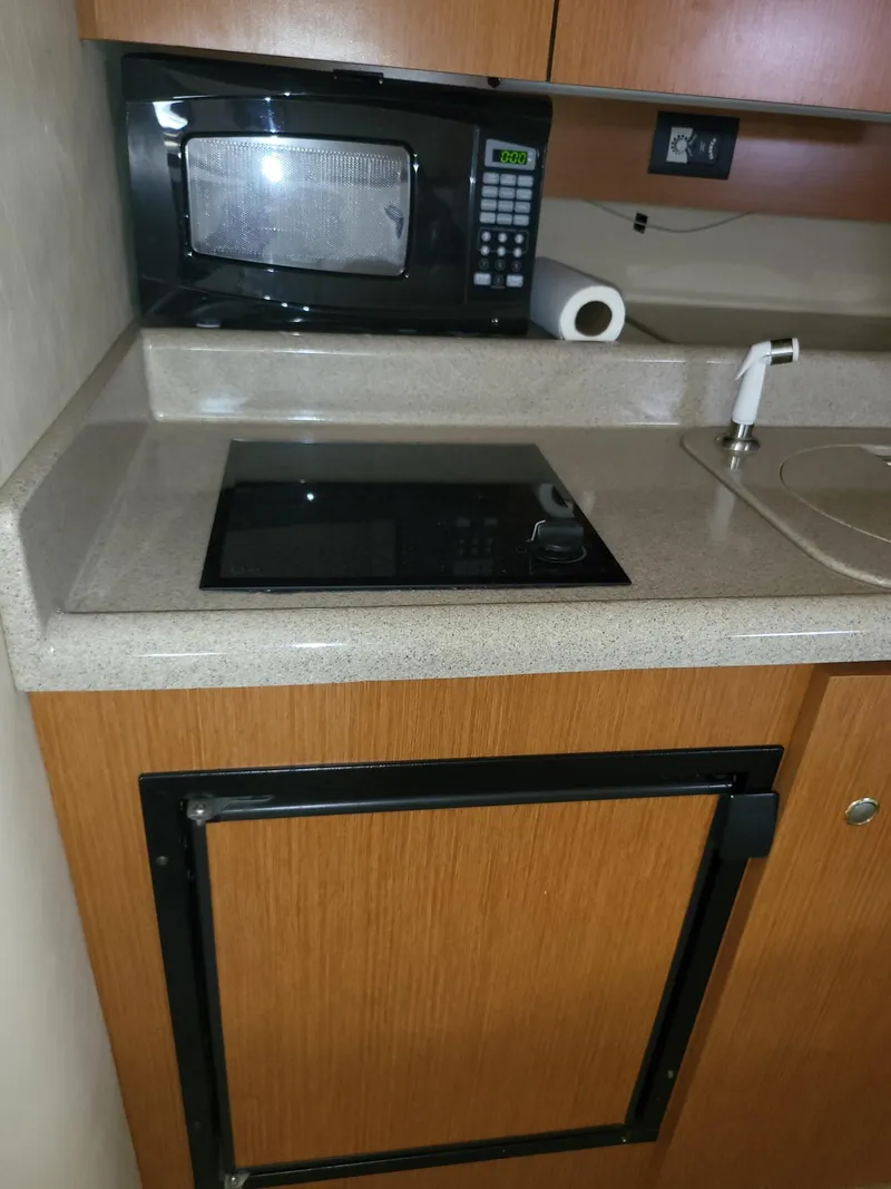 Slide: The Image of 2004 Cruisers 280CXi kitchenette with microwave, stovetop, and sink. - 8