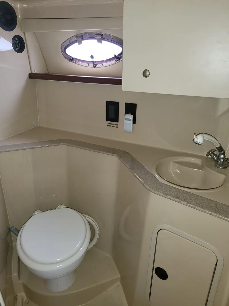 Slide: The Image of 2004 Cruisers 280CXi boat bathroom with toilet, sink, and storage cabinet. - 9