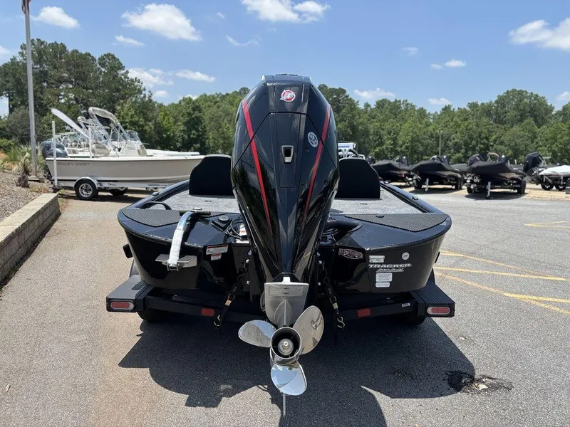 Slide: The Image of 2025 Tracker SAVAGE™ 215 boat, rear view, parked outdoors on a sunny day. - 2
