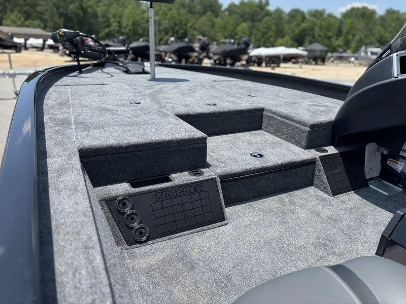 Slide: The Image of 2025 Tracker SAVAGE™ 215 boat deck with carpeted surface and storage compartments. - 4