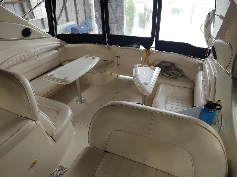 Slide: The Image of 1998 Maxum 4100 Sun Bridge SCR boat interior with beige seating and tables. - 11
