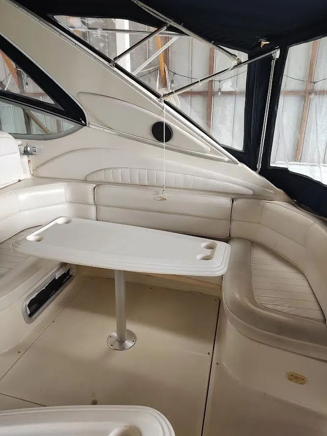 Slide: The Image of 1998 Maxum 4100 Sun Bridge SCR interior with white seating and table. - 14