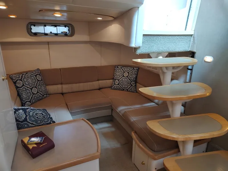 Slide: The Image of 1998 Maxum 4100 Sun Bridge SCR interior with beige seating and decorative pillows. - 19