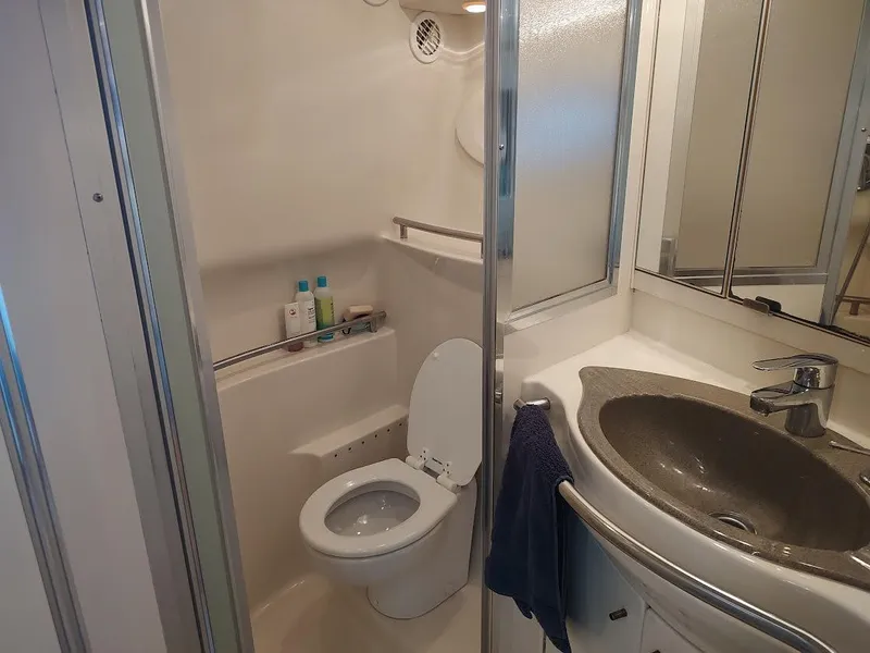 Slide: The Image of 1998 Maxum 4100 Sun Bridge SCR yacht bathroom with toilet, sink, and toiletries. - 21