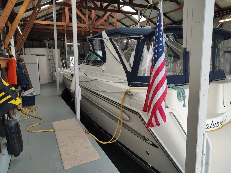 Slide: The Image of 1998 Maxum 4100 Sun Bridge SCR docked in a covered marina with American flag. - 7