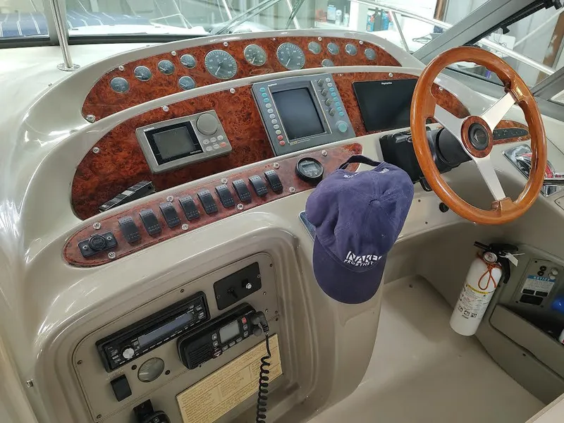 Slide: The Image of 1998 Maxum 4100 Sun Bridge SCR helm with wood accents, steering wheel, and navigation instruments. - 8