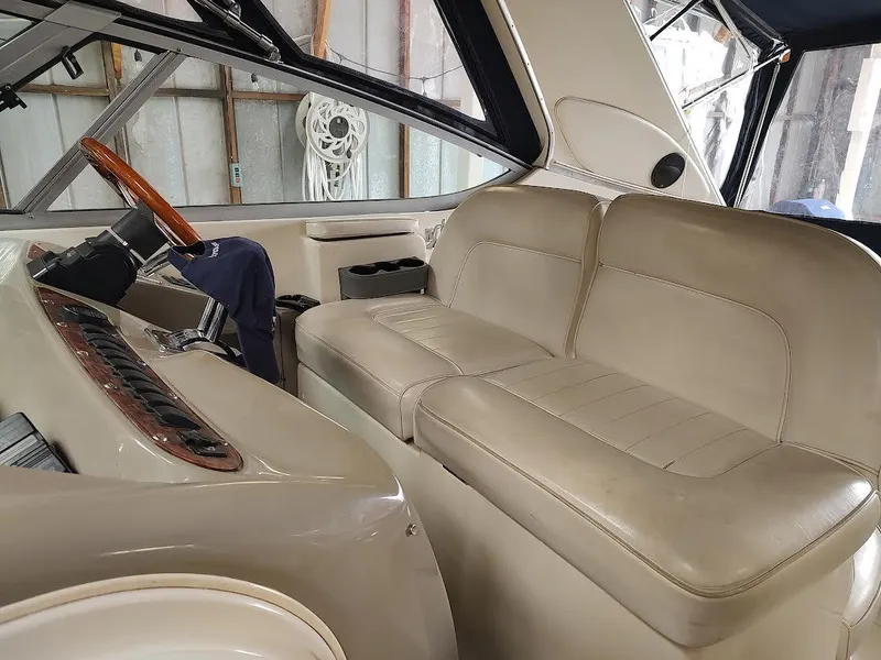 Slide: The Image of 1998 Maxum 4100 Sun Bridge SCR interior with beige seating and wooden steering wheel. - 9