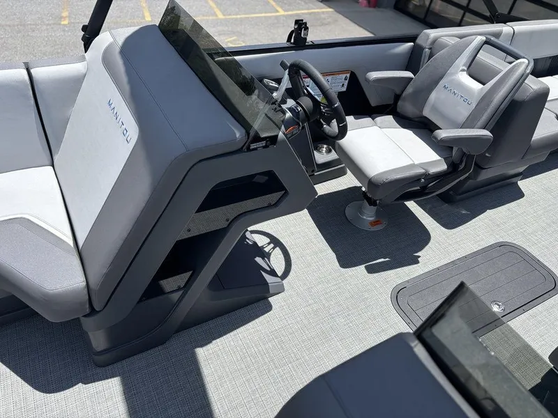 Slide: The Image of 2025 Manitou Cruise 22 Max Switchback boat interior with modern seating and steering console. - 13