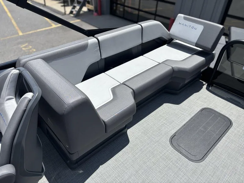 Slide: The Image of 2025 Manitou Cruise 22 Max Switchback boat interior with gray seating and modern design. - 15