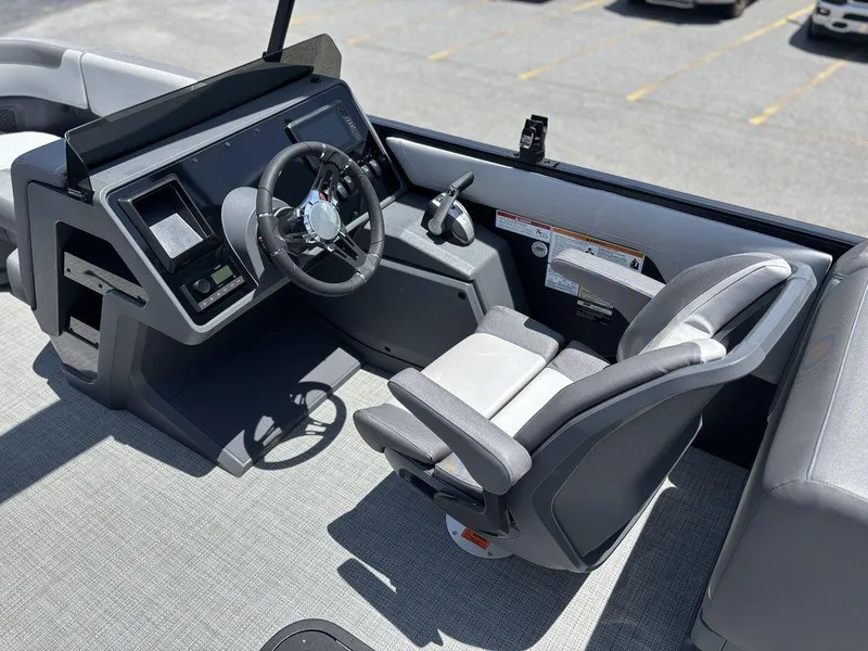 Slide: The Image of 2025 Manitou Cruise 22 Max Switchback boat cockpit with modern steering and seating. - 16