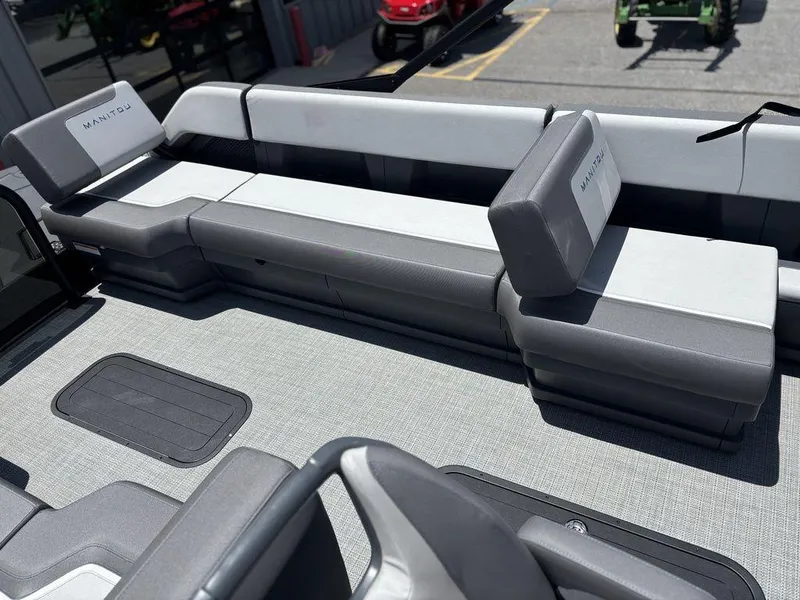 Slide: The Image of 2025 Manitou Cruise 22 Max Switchback boat interior with gray seating and flooring. - 19