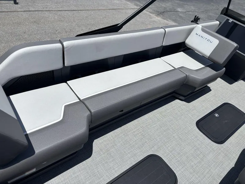 Slide: The Image of 2025 Manitou Cruise 22 Max Switchback boat seating, featuring sleek gray upholstery and modern design. - 20