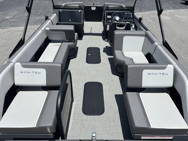 Slide: The Image of 2025 Manitou Cruise 22 Max Switchback pontoon boat interior with gray seating and modern dashboard. - 21