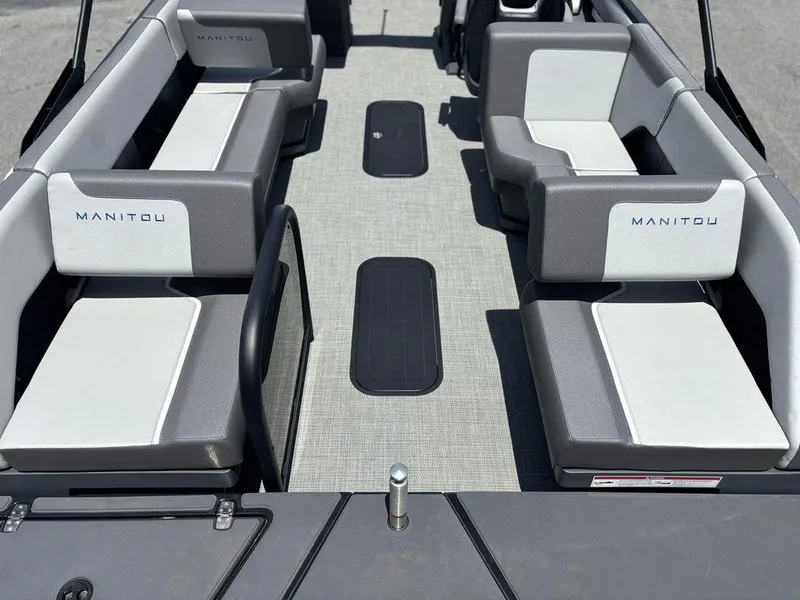 Slide: The Image of 2025 Manitou Cruise 22 Max Switchback interior with gray and white seating. - 24