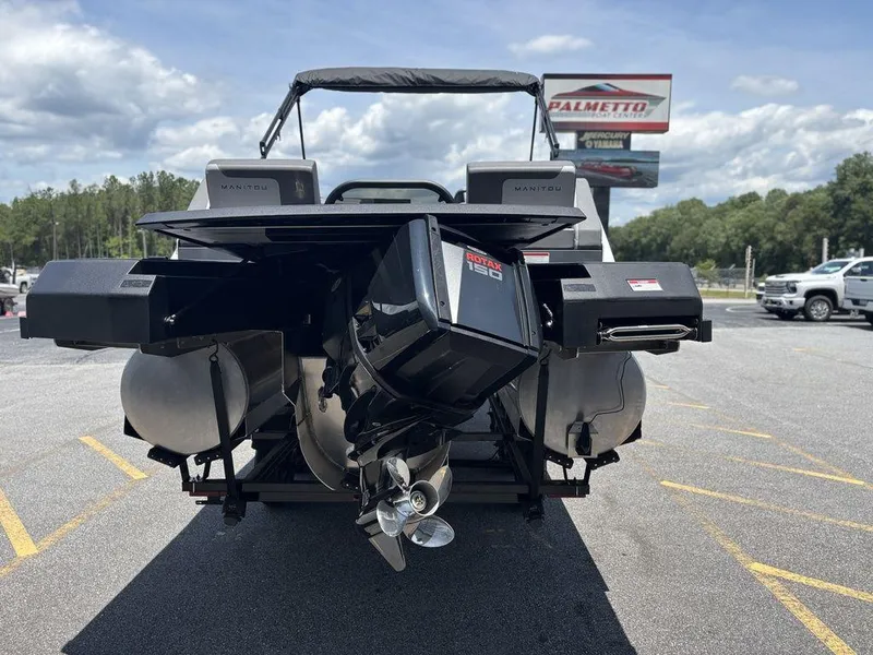 Slide: The Image of 2025 Manitou Cruise 22 Max Switchback boat with Rotax engine, parked outdoors. - 5