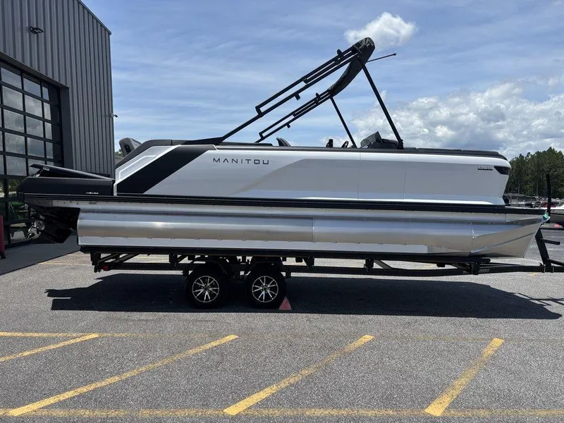 Slide: The Image of 2025 Manitou Cruise 22 Max Switchback pontoon boat on trailer, parked outdoors. - 7