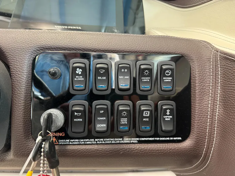 Slide: The Image of Control panel of a 2025 Regal LS6 boat with various function switches. - 12