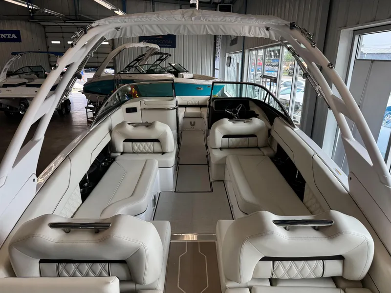 Slide: The Image of 2025 Regal LS6 boat interior with luxurious white seating and modern design in a showroom. - 22