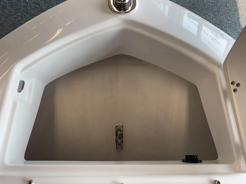 Slide: The Image of 2025 Regal LS6 boat storage compartment, open and empty, with white interior. - 6