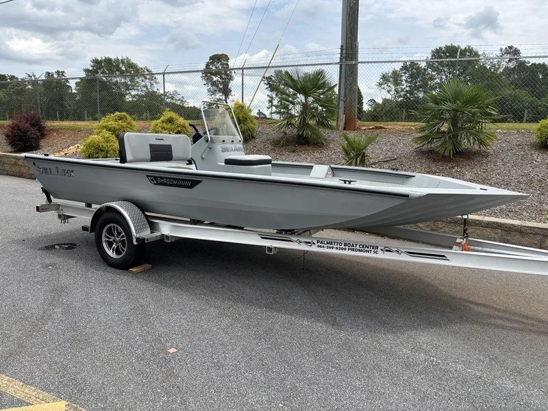 The Image of 2025 SeaArk Shadow 18 Center Console boat on trailer, parked outdoors. - 1