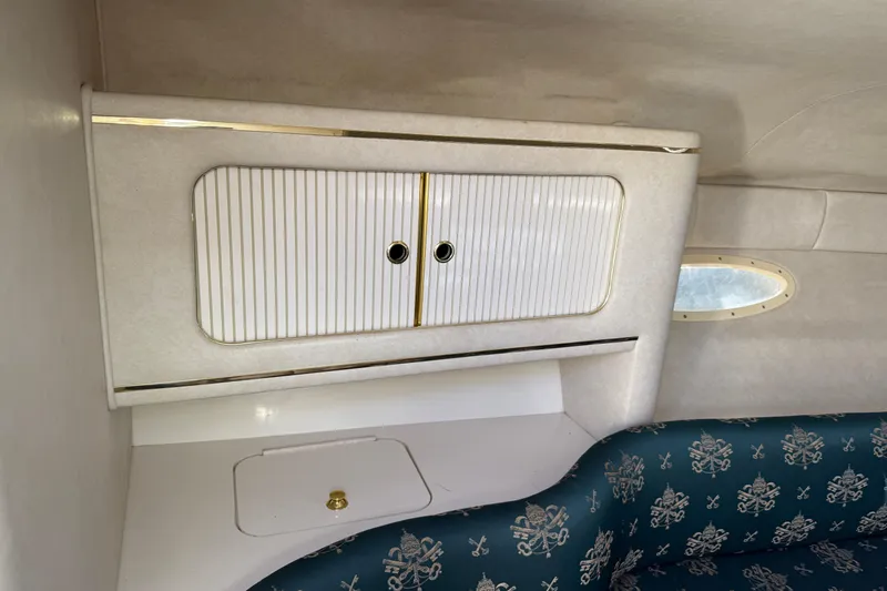 Slide: The Image of Interior of 1998 Sea Ray 280 Sun Sport with storage cabinet and patterned seating. - 12