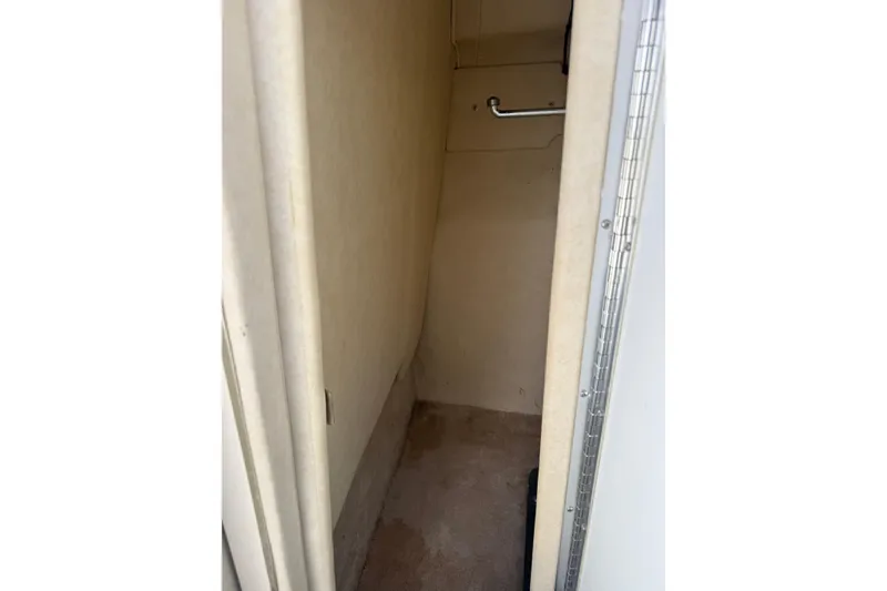 Slide: The Image of Interior view of 1998 Sea Ray 280 Sun Sport cabin space, featuring beige walls and flooring. - 18