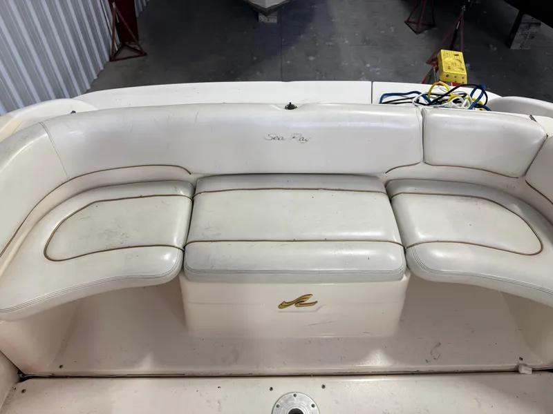 Slide: The Image of 1998 Sea Ray 280 Sun Sport boat seating with white upholstery in a storage area. - 4