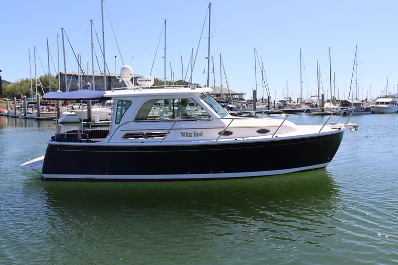 The Image of 2011 Back Cove 30 boat docked in marina, clear sky, calm water. - 0