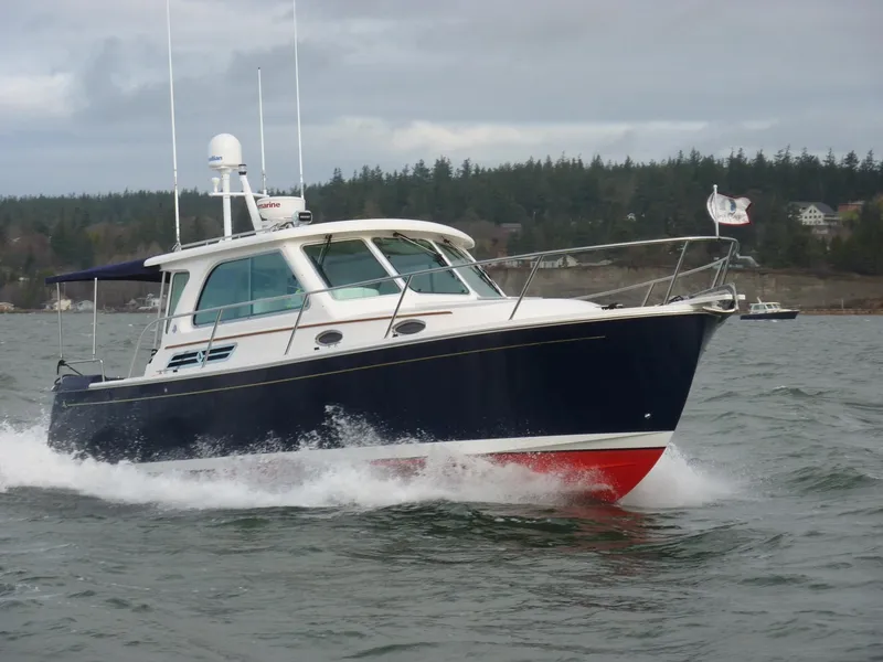 Slide: The Image of 2011 Back Cove Express Cruiser navigating through water with forested shoreline in background. - 10