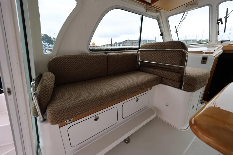 Slide: The Image of 2011 Back Cove 30 interior seating area with patterned cushions and storage compartments. - 12