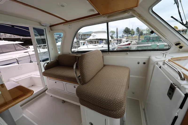 Slide: The Image of Interior of a 2011 Back Cove 30 boat with cushioned seating and marina view. - 14