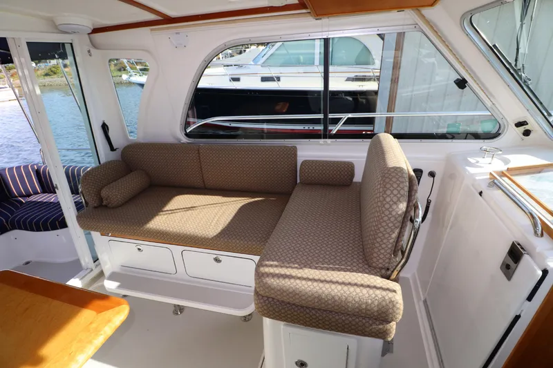 Slide: The Image of 2011 Back Cove Express Cruiser interior with comfortable seating and scenic window views. - 15