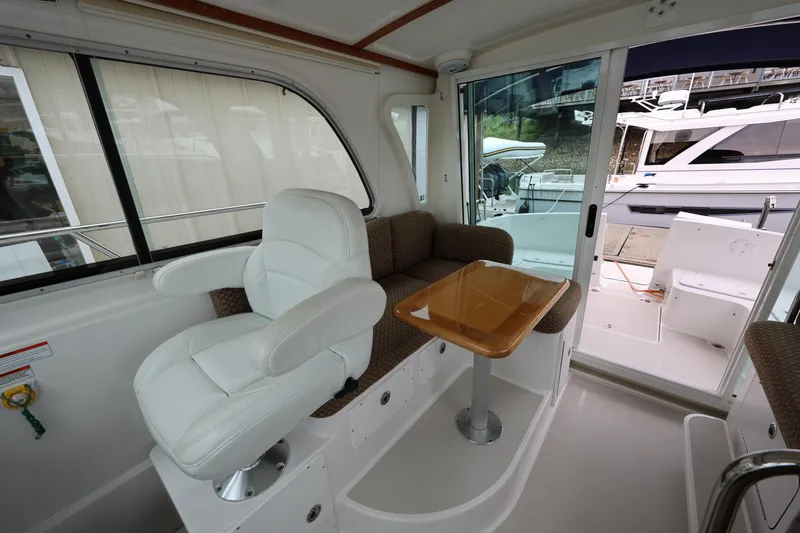 Slide: The Image of Interior of 2011 Back Cove 30 boat with white seating and wooden table. - 17