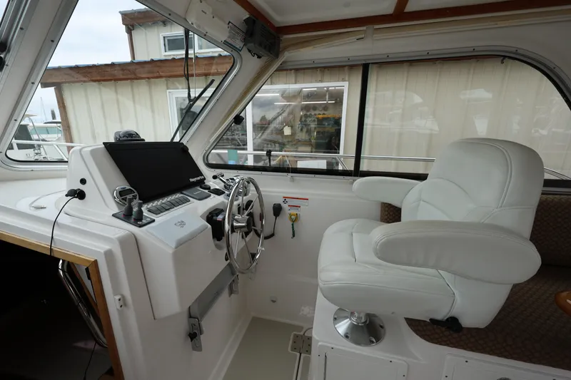Slide: The Image of 2011 Back Cove 30 helm with white captain's chair and navigation controls. - 18