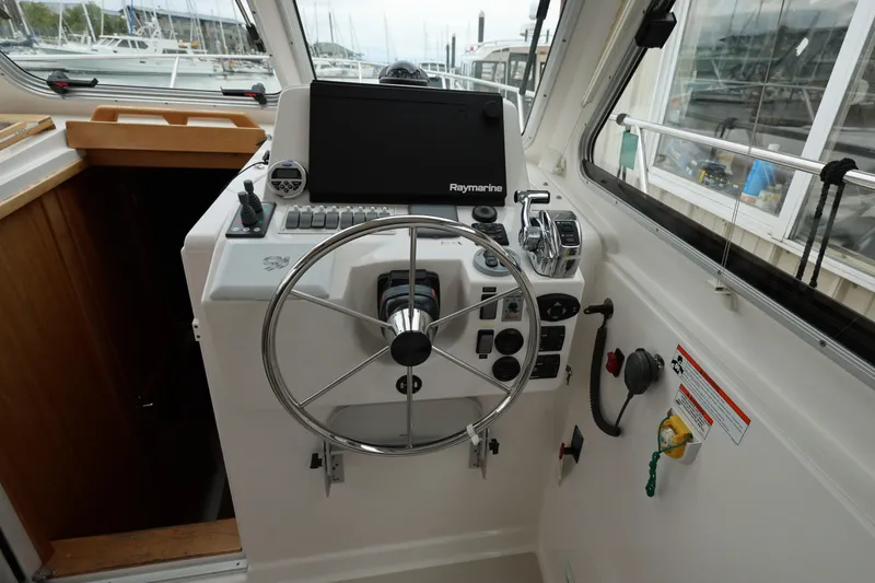 Slide: The Image of Helm of 2011 Back Cove 30 boat with steering wheel and navigation controls. - 19