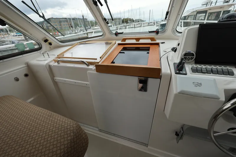 Slide: The Image of 2011 Back Cove 30 boat interior with helm station and marina view. - 20