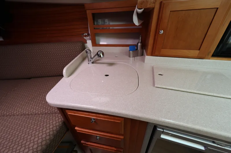 Slide: The Image of Interior of 2011 Back Cove 30 boat featuring a compact kitchen area with sink and cabinets. - 29