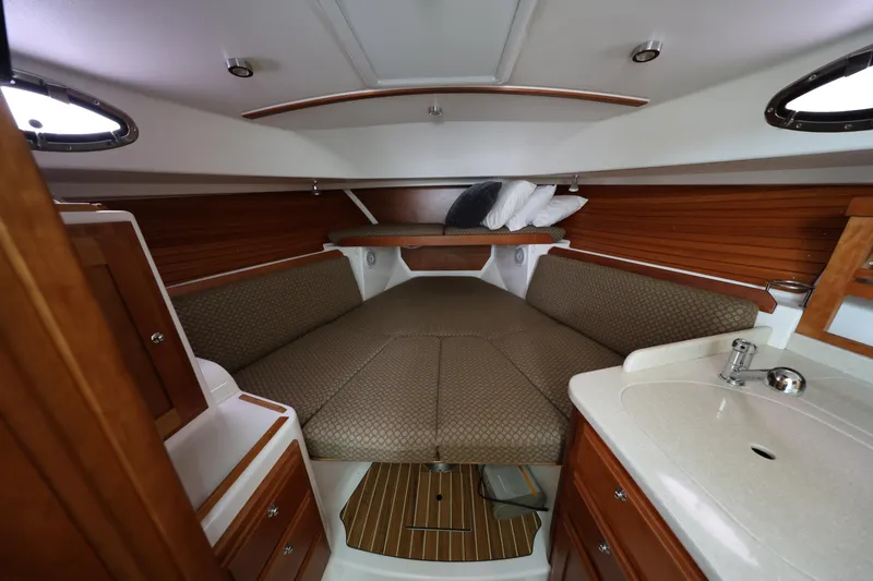 Slide: The Image of 2011 Back Cove 30 interior cabin with cozy seating and wooden accents. - 30