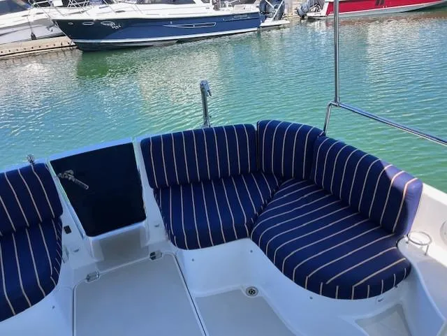 Slide: The Image of 2011 Back Cove 30 boat with striped seating, docked in a marina. - 32