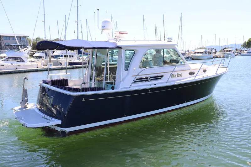 Slide: The Image of 2011 Back Cove 30 boat docked in marina, featuring sleek design and blue hull. - 5