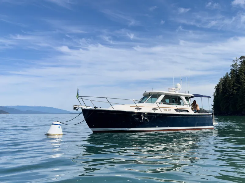 Slide: The Image of 2011 Back Cove Express Cruiser anchored on calm water under a clear blue sky. - 9