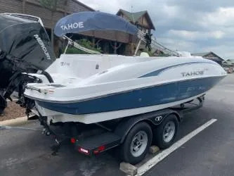 The Image of 2023 Tahoe 2150 Deck Boat on trailer, parked outdoors with Mercury engine. - 0