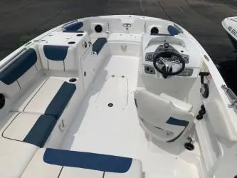Slide: The Image of 2023 Tahoe 2150 Deck Boat interior with blue and white seating and steering console. - 3